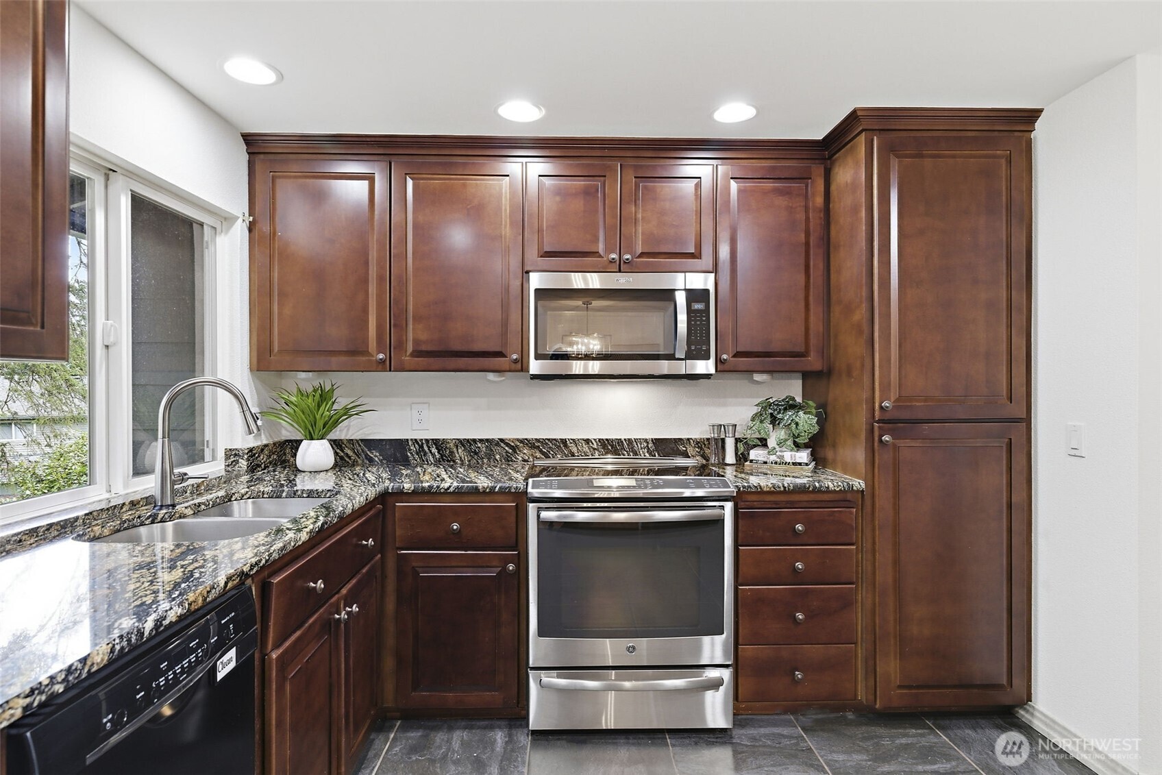 927 217th Street Southwest Bothell, WA 98021 - Photo 9 of 33 a kitchen with kitchen island granite countertop wooden cabinets stainless steel appliances and a sink