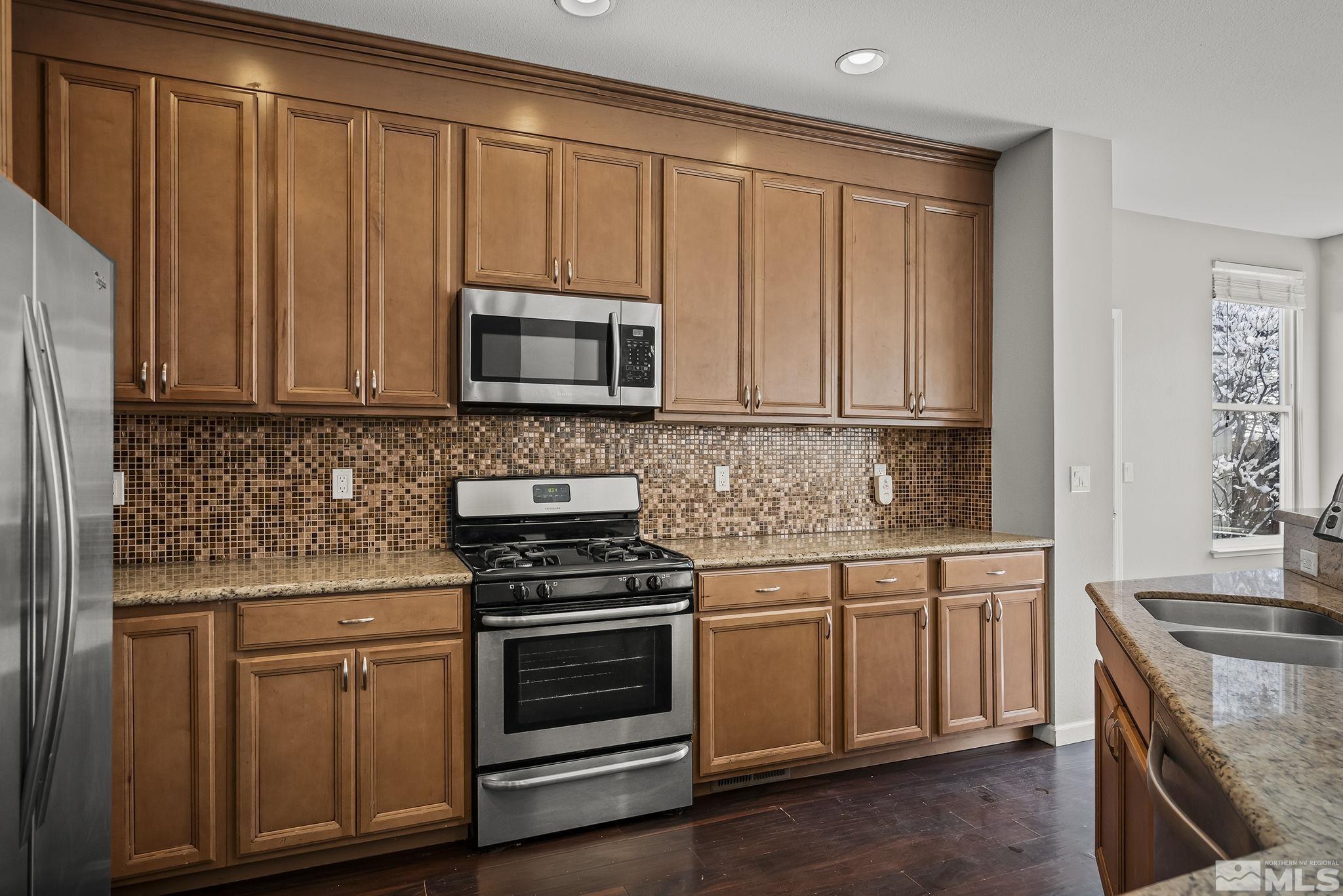 720 Caughlin Glen Reno, NV 89519 - Photo 12 of 24 a kitchen with granite countertop white cabinets and stainless steel appliances
