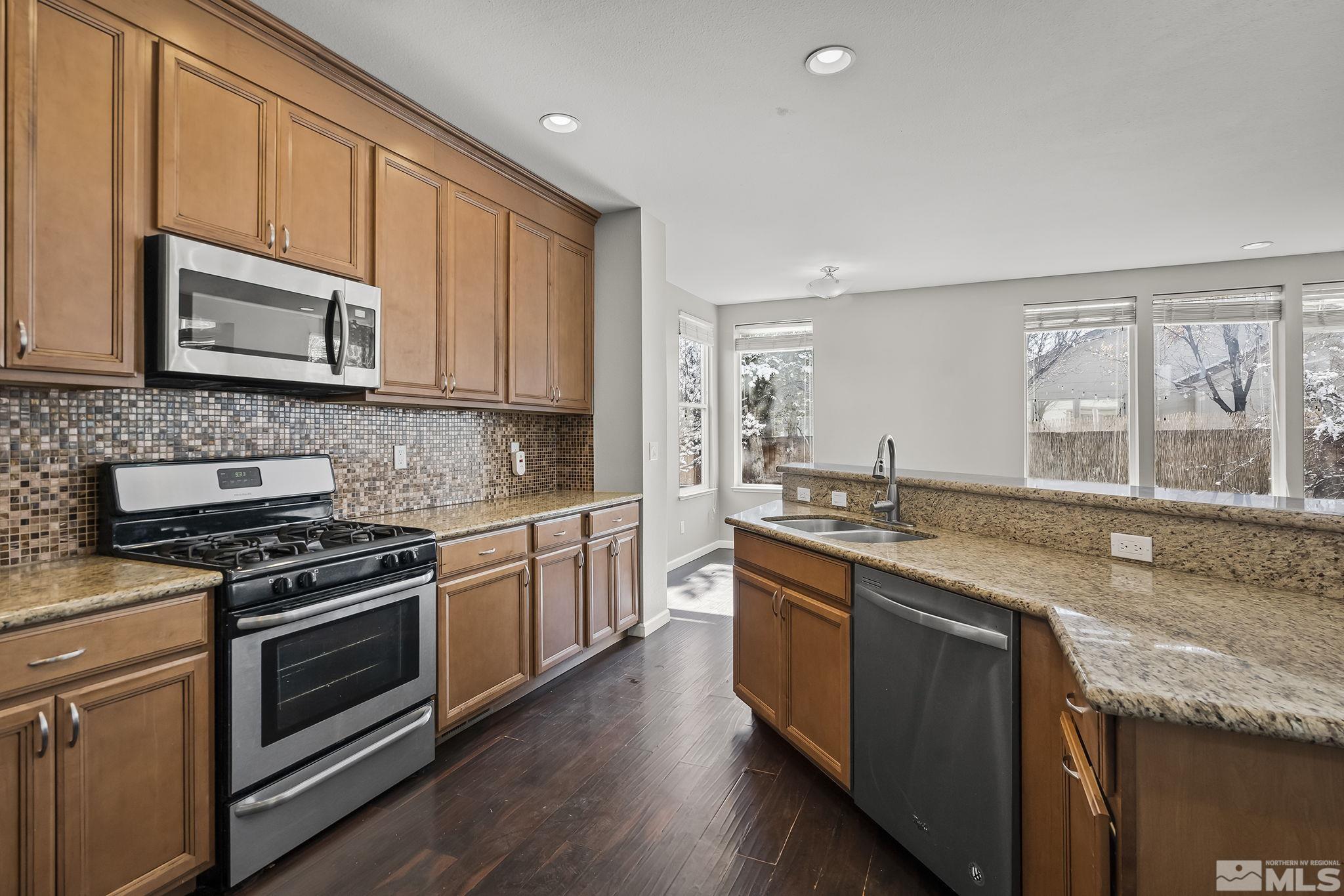 720 Caughlin Glen Reno, NV 89519 - Photo 13 of 24 a kitchen with stainless steel appliances granite countertop wooden cabinets stove top oven and sink