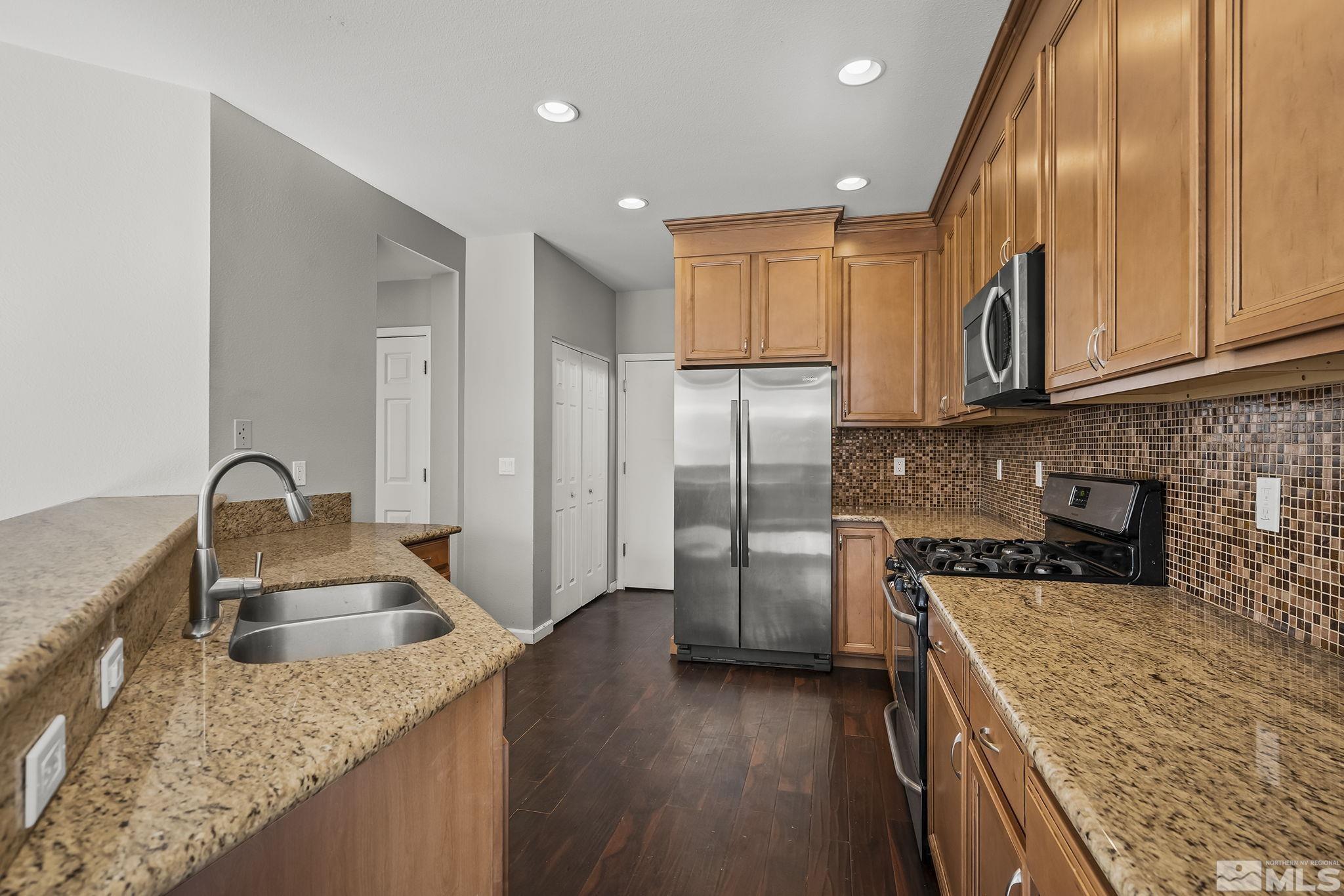 720 Caughlin Glen Reno, NV 89519 - Photo 14 of 24 a kitchen with stainless steel appliances granite countertop a sink stove and refrigerator