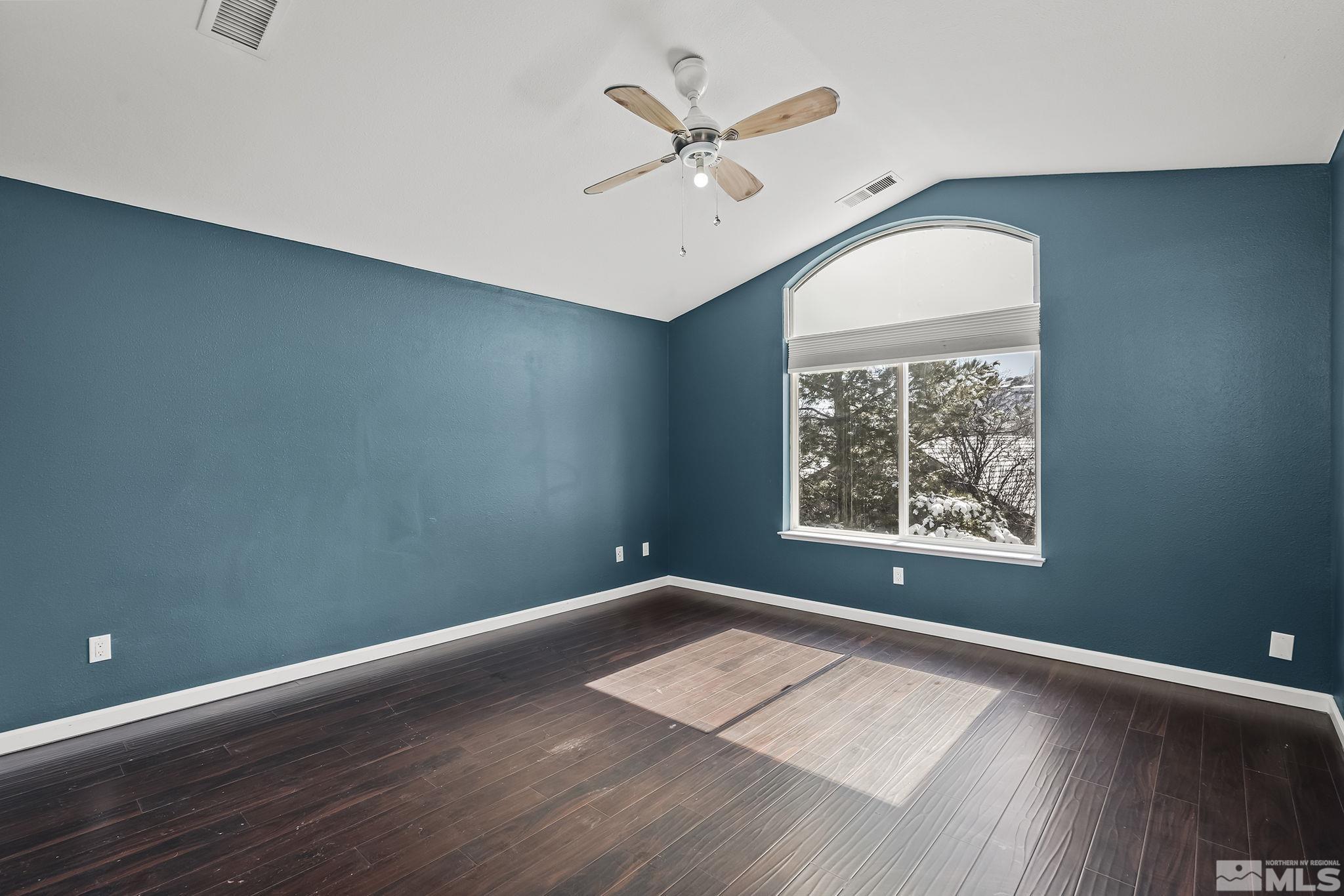 720 Caughlin Glen Reno, NV 89519 - Photo 15 of 24 an empty room with wooden floor chandelier fan and windows