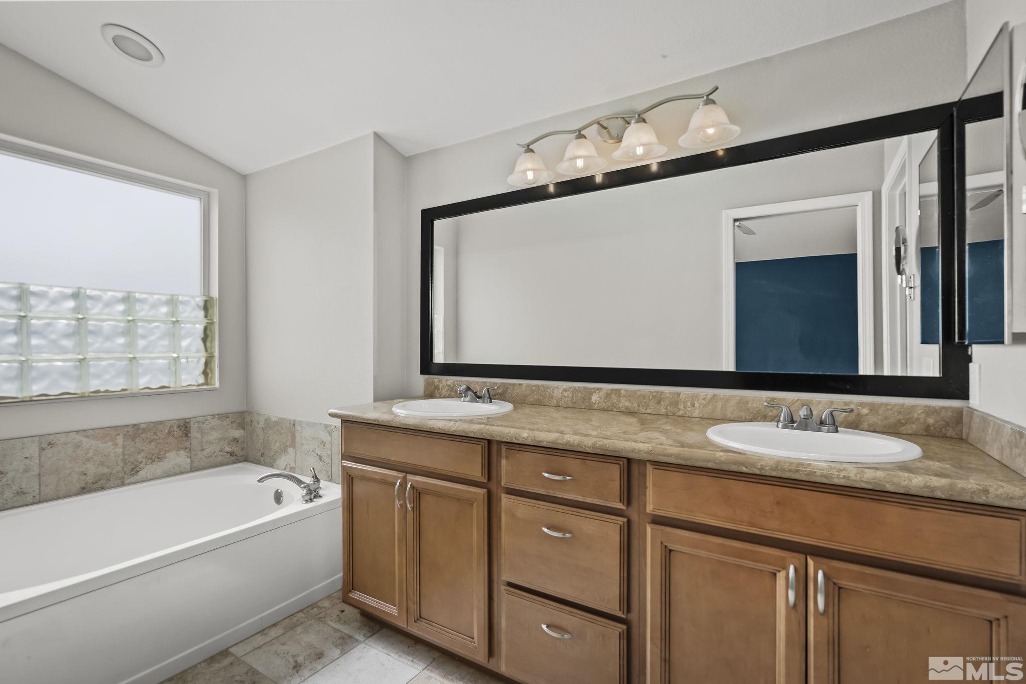 720 Caughlin Glen Reno, NV 89519 - Photo 16 of 24 a bathroom with a granite countertop sink mirror and a bathtub