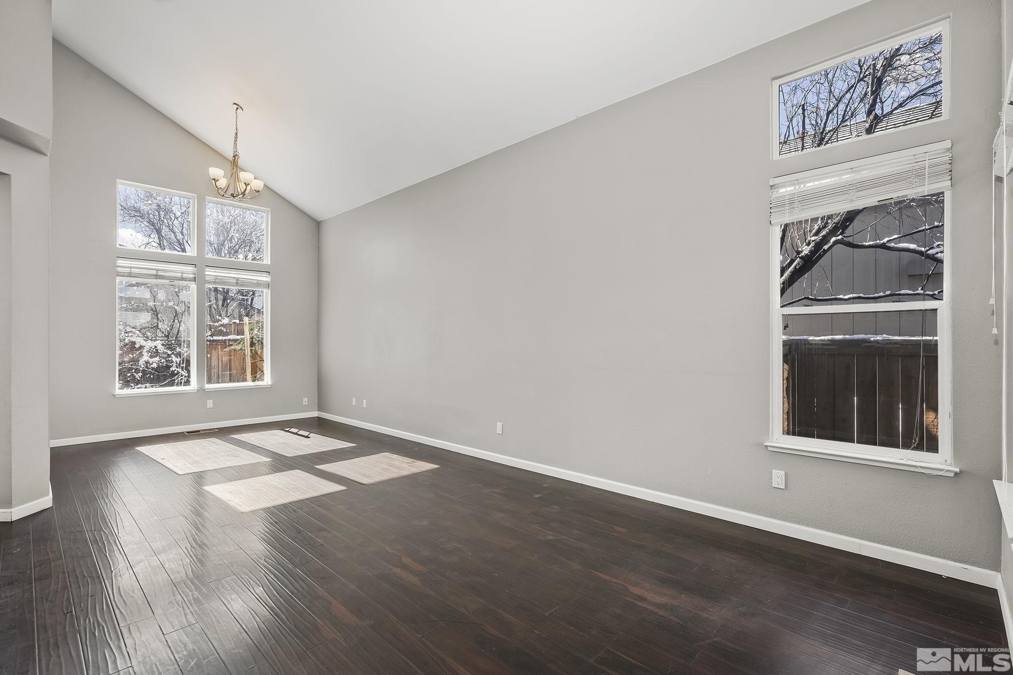 720 Caughlin Glen Reno, NV 89519 - Photo 4 of 24 an empty room with wooden floor cabinet and windows
