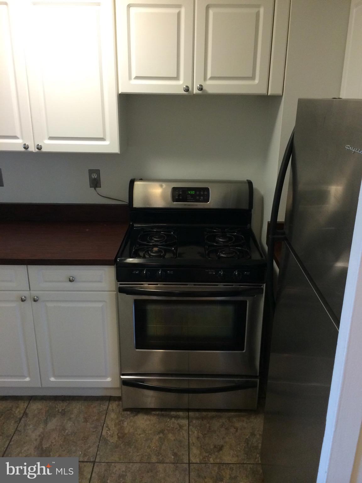 803 3rd Street Southwest, Unit 706 Washington, DC 20024 - Photo 6 of 18 a kitchen with granite countertop white cabinets and stainless steel appliances
