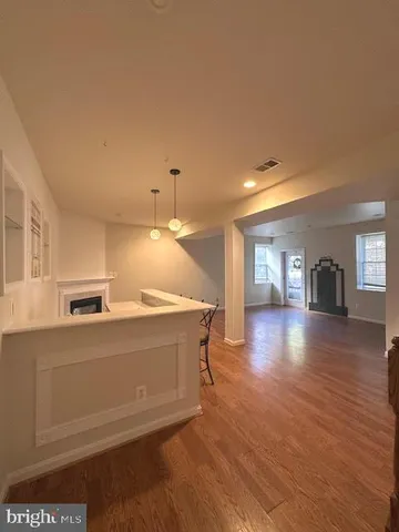 a view of a kitchen with a sink and dishwasher a stove top oven with wooden floor