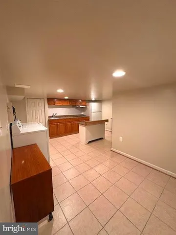 a kitchen with stainless steel appliances kitchen island granite countertop a refrigerator and a stove top oven