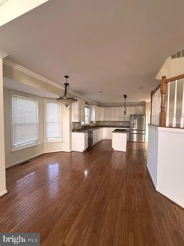 a view of a kitchen with wooden floor and a kitchen
