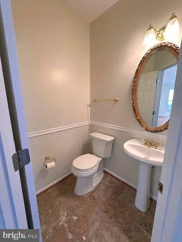 a bathroom with a toilet a sink and a mirror
