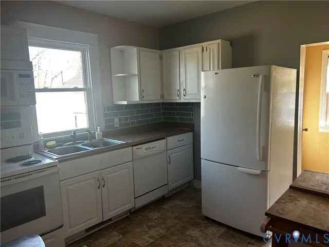 a kitchen with appliances a sink and a window