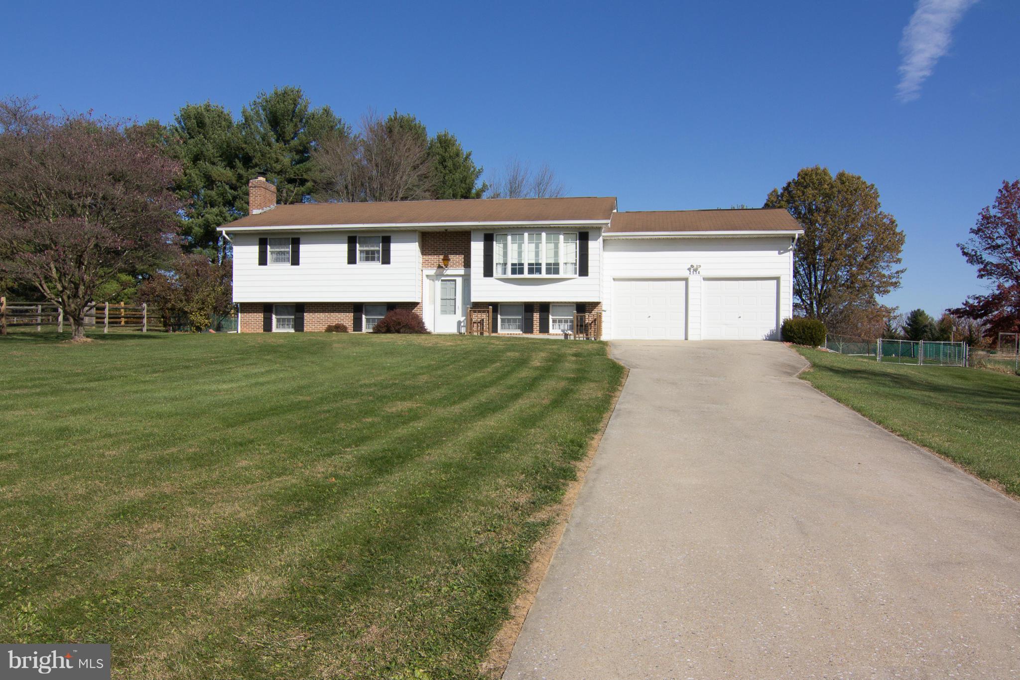 a view of a yard in front of a house with large tree