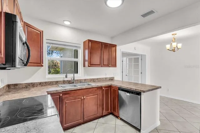 a kitchen with granite countertop stainless steel appliances a sink stove and microwave