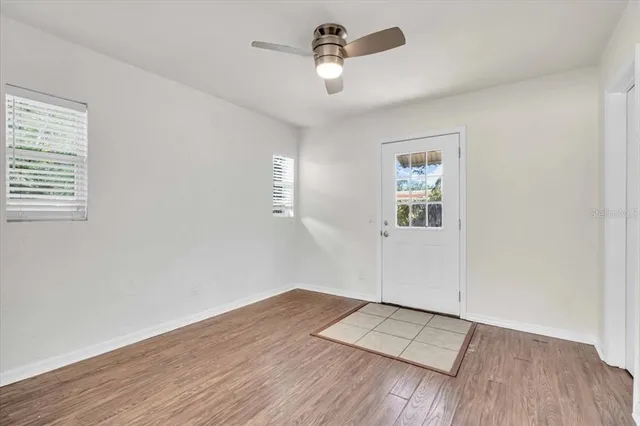 an empty space with wooden floor closet and windows