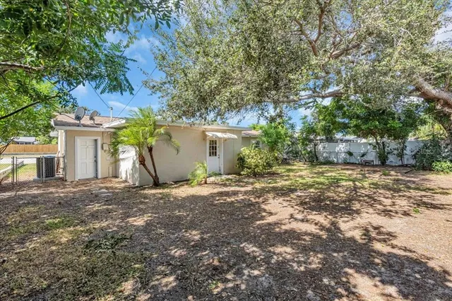 a view of a yard with plants and trees