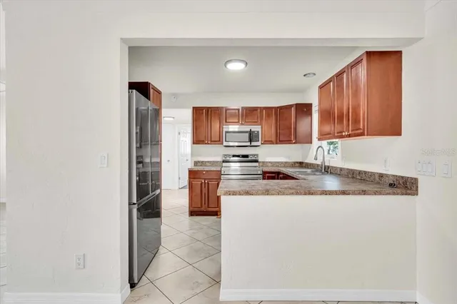 a kitchen with stainless steel appliances granite countertop a refrigerator and a stove top oven