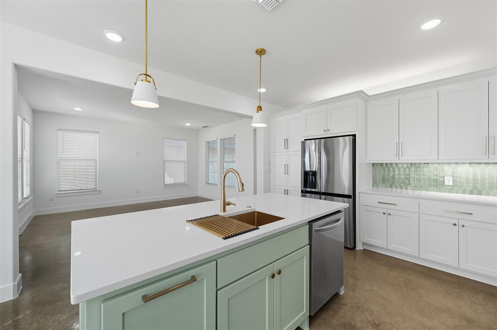 100 Cardinal Wds Granbury, TX 76049 - Photo 11 of 36 Kitchen with green cabinetry, finished concrete floors, tasteful backsplash, white cabinetry, and decorative light fixtures