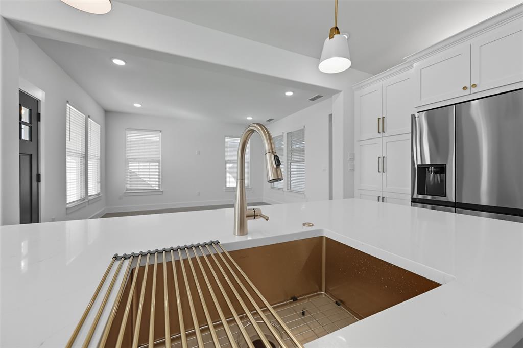 100 Cardinal Wds Granbury, TX 76049 - Photo 36 of 36 Kitchen with stainless steel refrigerator with ice dispenser, recessed lighting, open floor plan, light stone counters, and pendant lighting