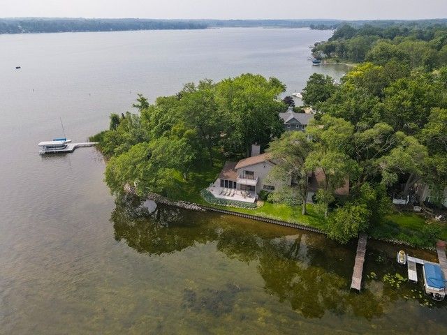 an aerial view of a house with a yard and lake view
