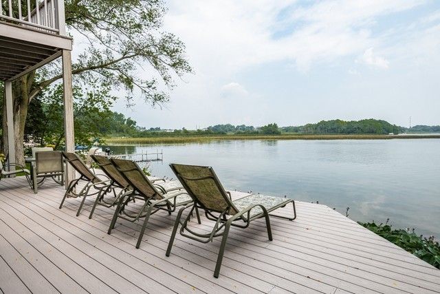 a view of a lake with table and chairs