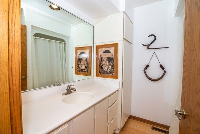a bathroom with a granite countertop sink a mirror and a shower