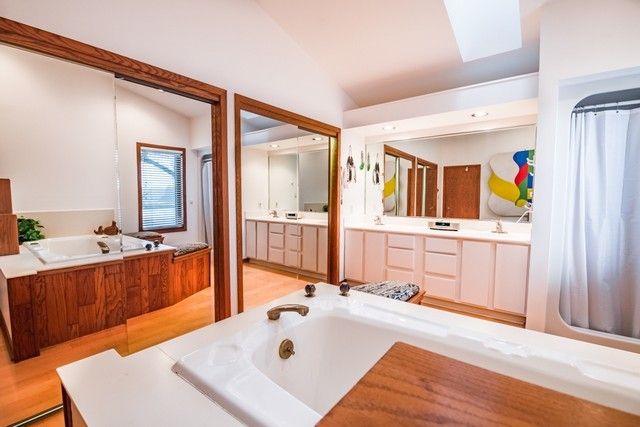 a bathroom with a tub sink and mirror