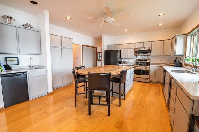 a kitchen with a table chairs refrigerator and microwave