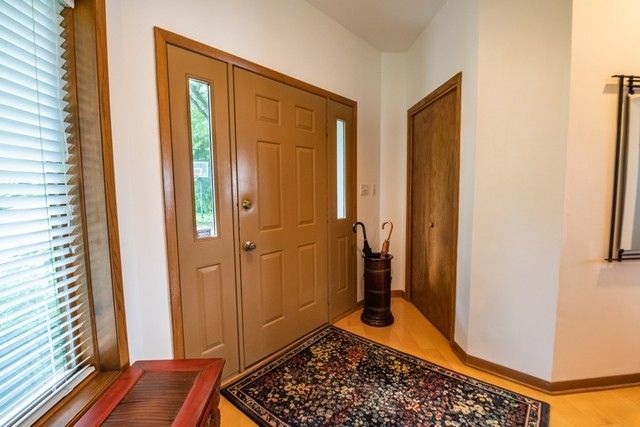 a view of a hallway with wooden floor and a livingroom with furniture