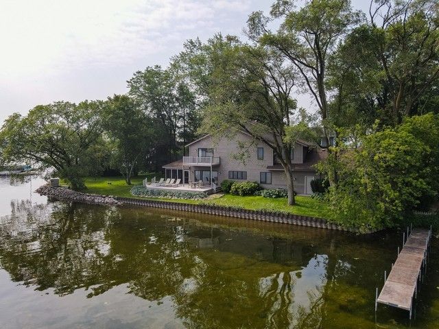 a view of house with outdoor space and a lake view in back