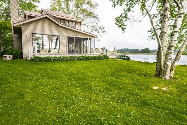 a view of a house with a yard and a large tree