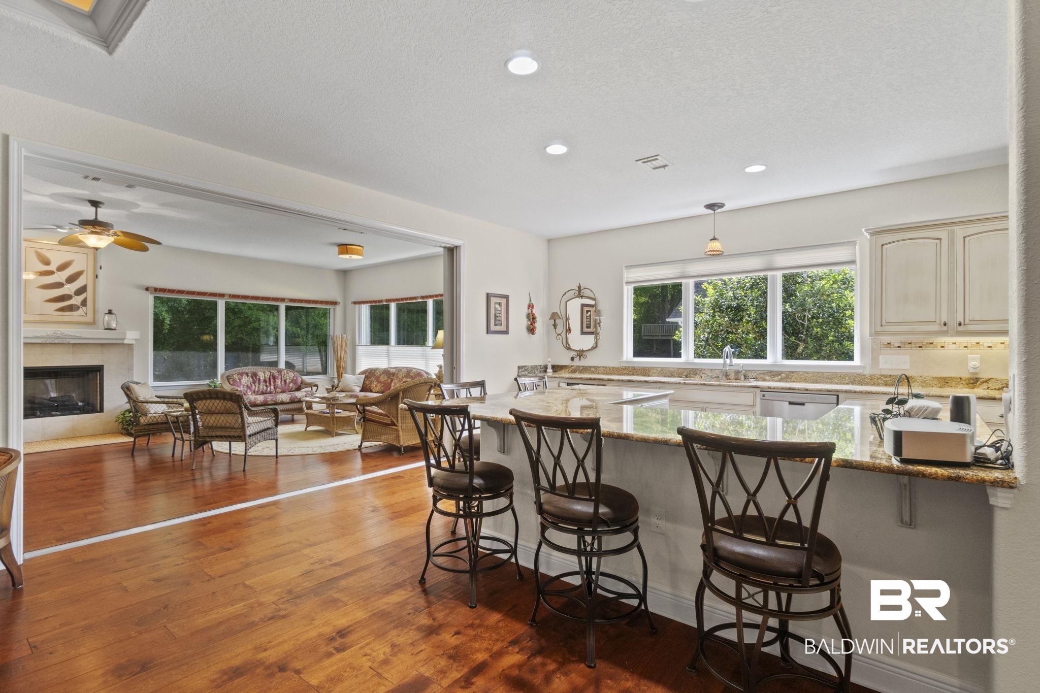 8664 Foxtail Loop Pensacola, FL 32526 - Photo 62 of 64 Kitchen with cream cabinetry, a kitchen breakfast bar, open floor plan, hardwood / wood-style flooring, and recessed lighting