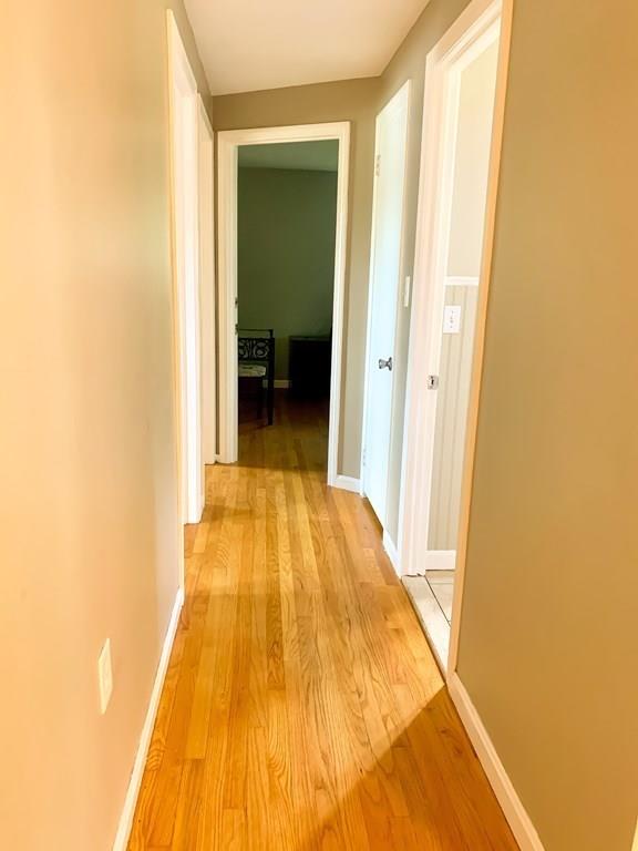 896 Tinkham Road Wilbraham, MA 01095 - Photo 8 of 30 a view of a hallway with wooden floor and a bathroom