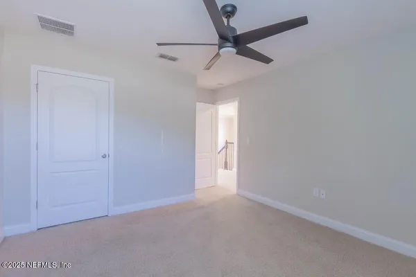 an empty room with a ceiling fan and a window