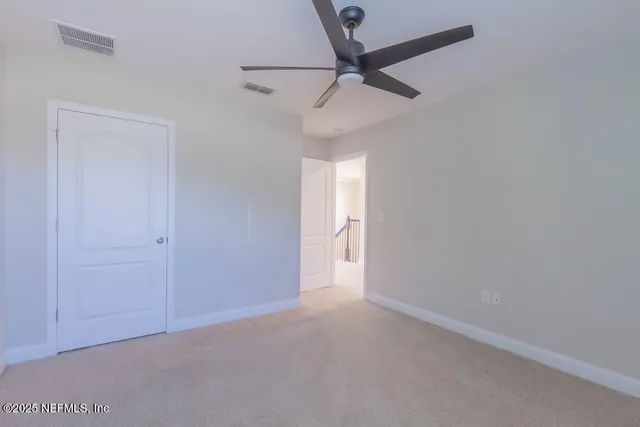 an empty room with a ceiling fan and a window