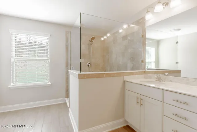 a bathroom with a shower sink and mirror