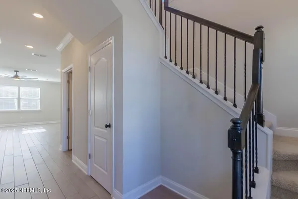 a view of a hallway with wooden floor and staircase