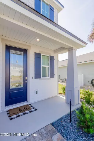 a view of a house with a yard and potted plants