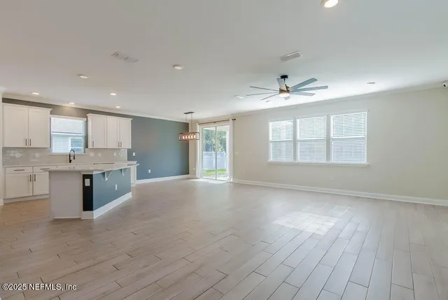a view of an empty room with a kitchen