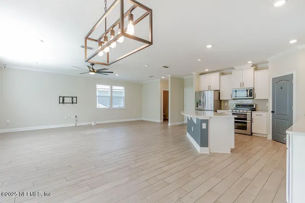a view of kitchen with refrigerator stove microwave and cabinets