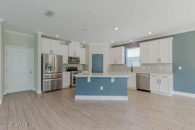 a kitchen with stainless steel appliances a refrigerator sink and microwave