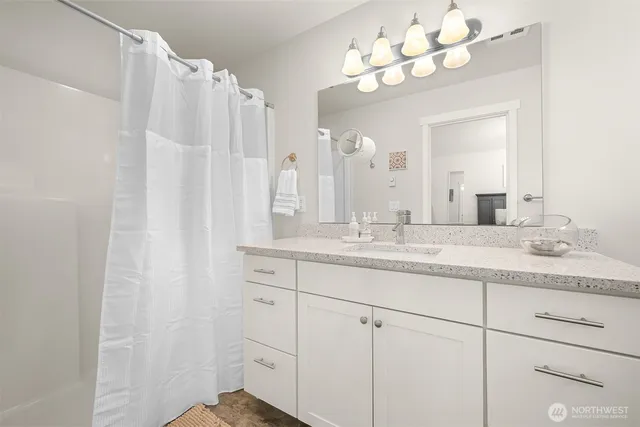 a bathroom with a sink vanity granite and a mirror