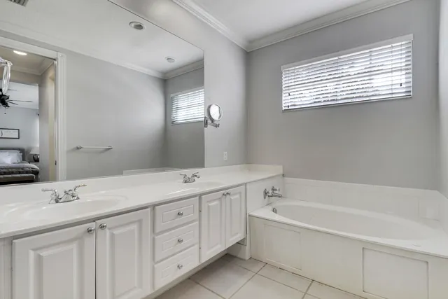 a spacious bathroom with a tub double sink and mirror