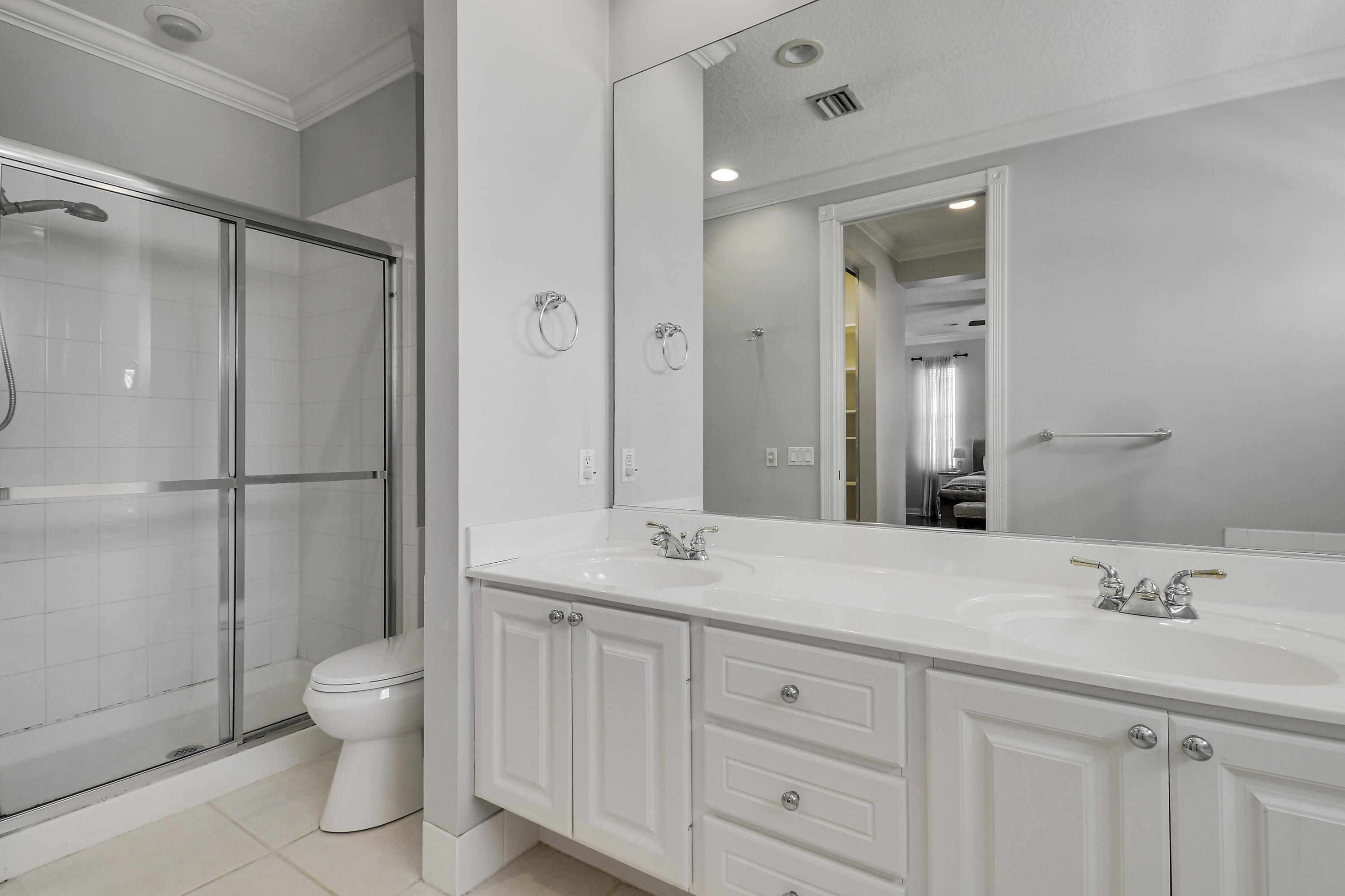 131 Rockingham Road Jupiter, FL 33458 - Photo 31 of 40 a spacious bathroom with a granite countertop sink a toilet and a mirror