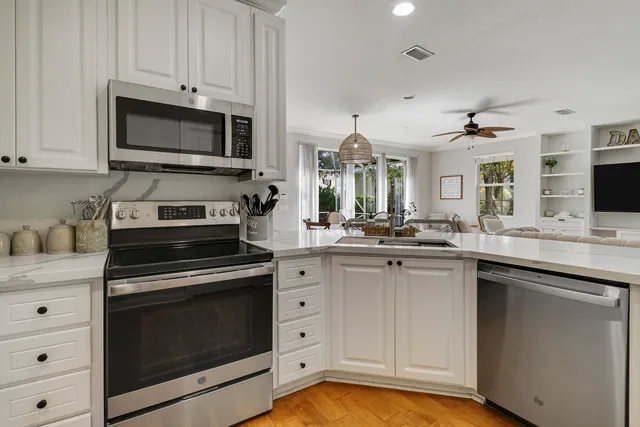a kitchen with white cabinets stainless steel appliances and sink