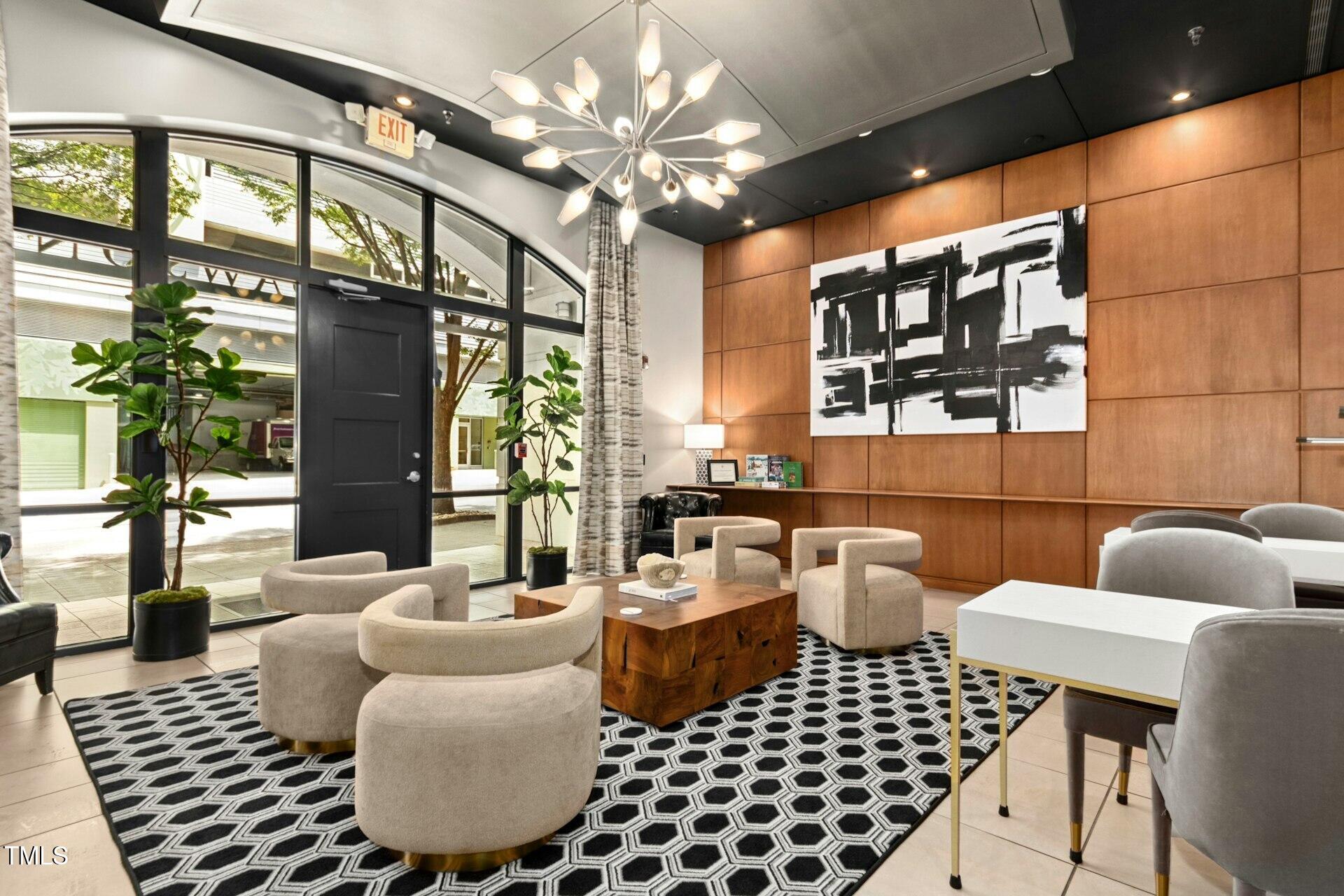 a living room with furniture a chandelier and a floor to ceiling window