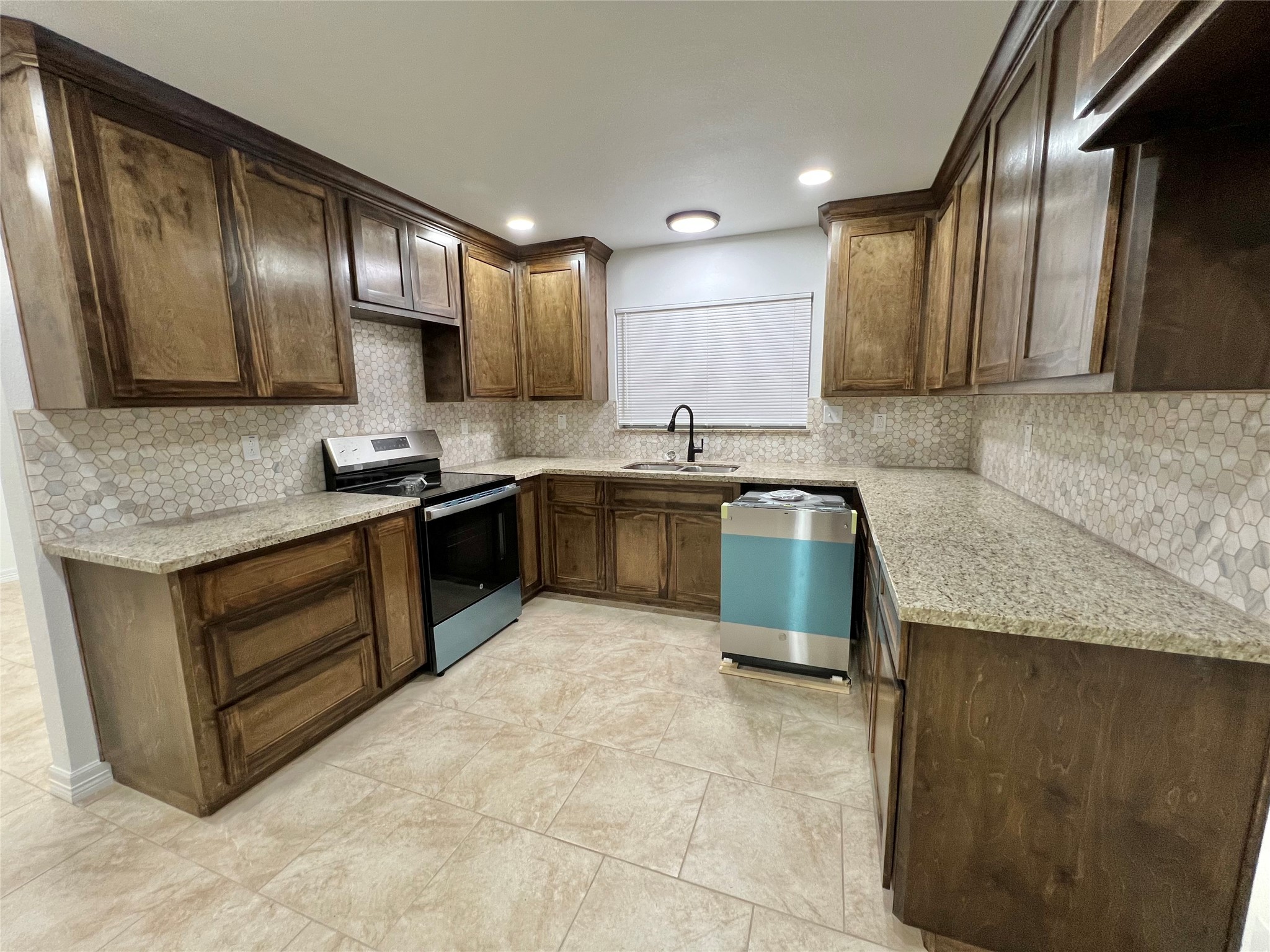5 Colony Drive Angleton, TX 77515 - Photo 19 of 34 a kitchen with stainless steel appliances granite countertop a sink stove and cabinets