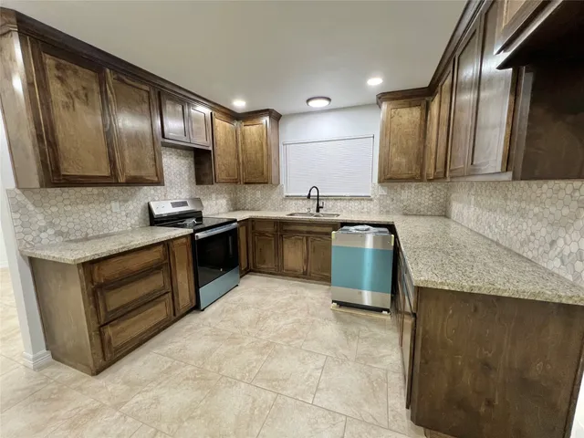 a kitchen with a stove a sink and a refrigerator