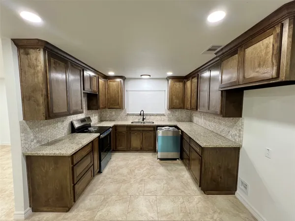 a kitchen with a stove a sink and a refrigerator