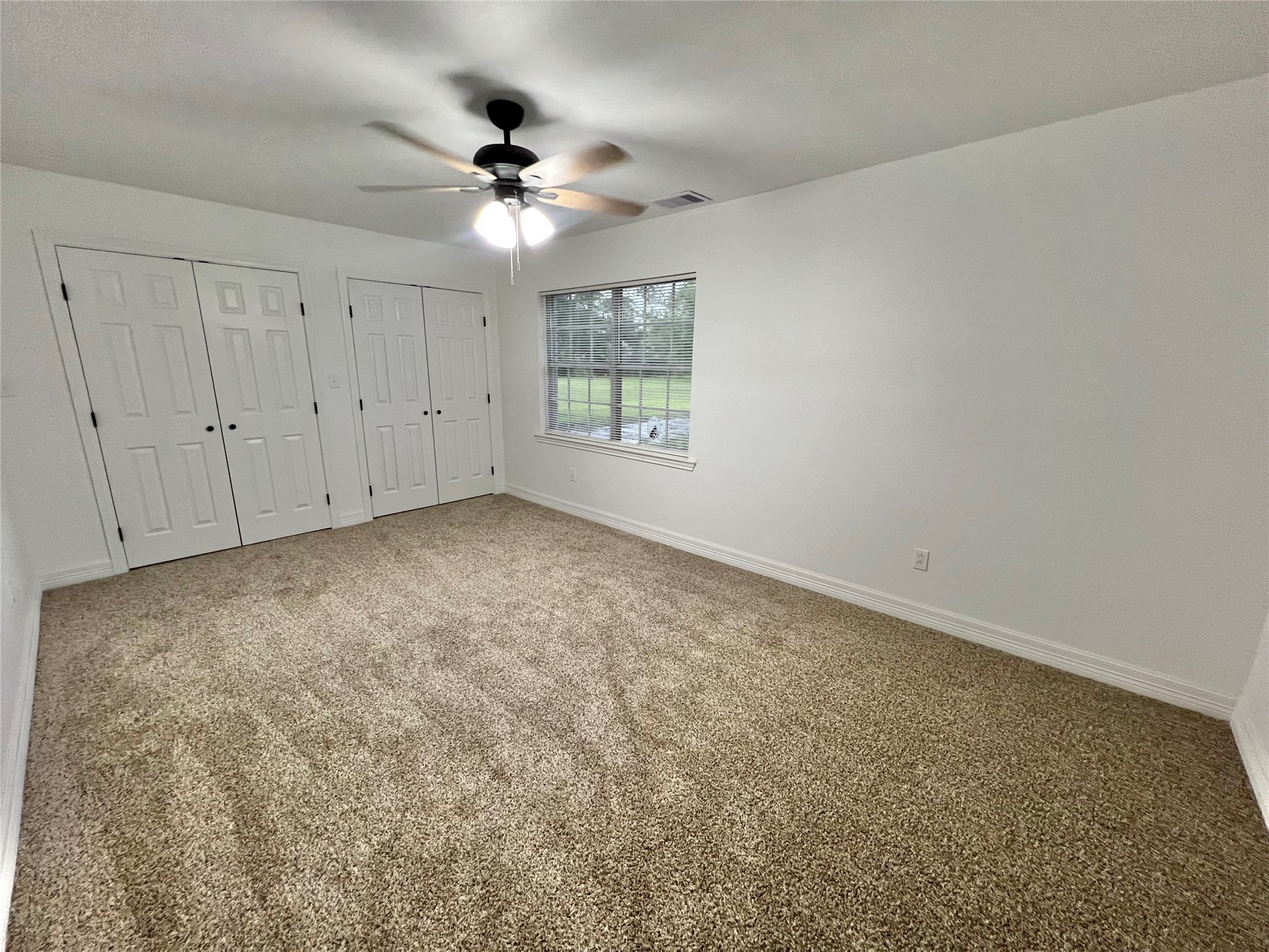 5 Colony Drive Angleton, TX 77515 - Photo 26 of 34 an empty room with a chandelier fan and windows