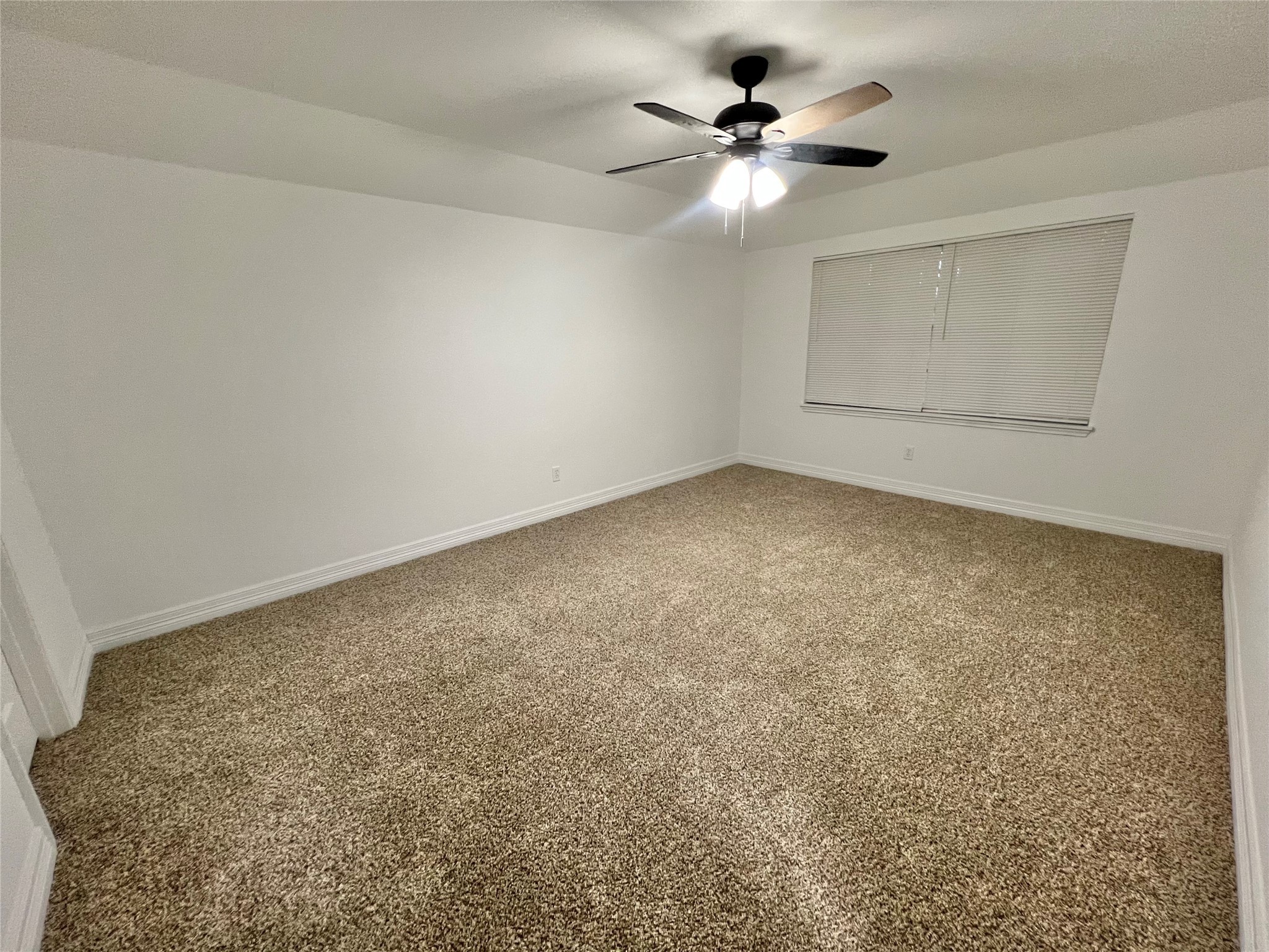 5 Colony Drive Angleton, TX 77515 - Photo 27 of 34 an empty room with a chandelier fan and windows
