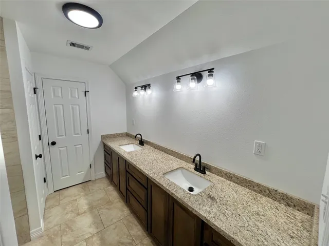 a bathroom with a granite countertop sink a toilet and shower