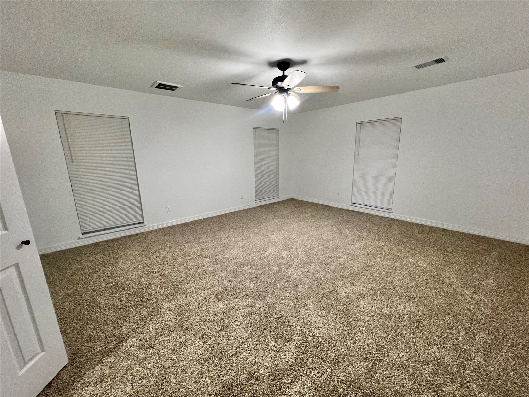 5 Colony Drive Angleton, TX 77515 - Photo 5 of 34 an empty room with a chandelier fan and windows